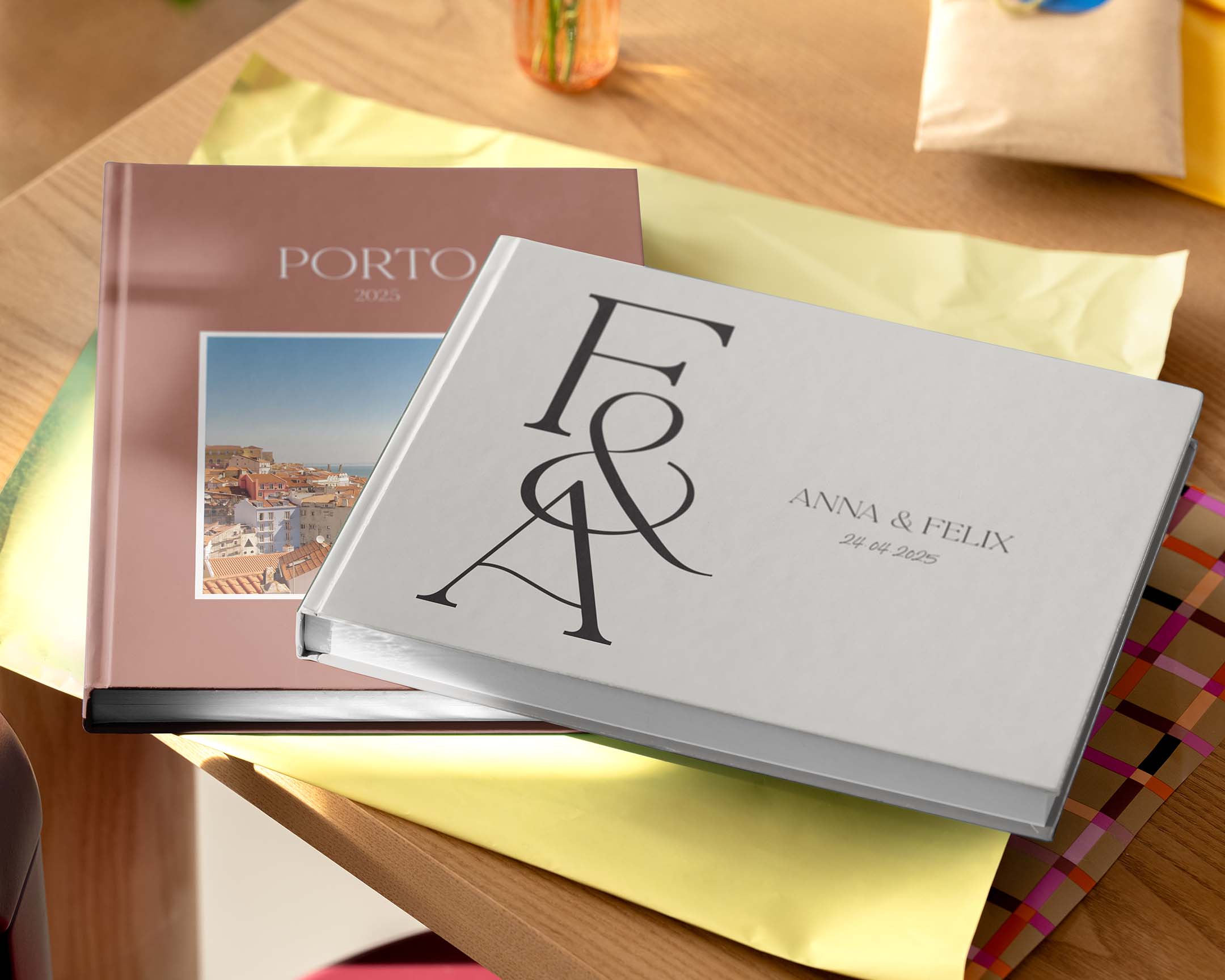 Two personalised photo books displayed on a table in different sizes and designs.