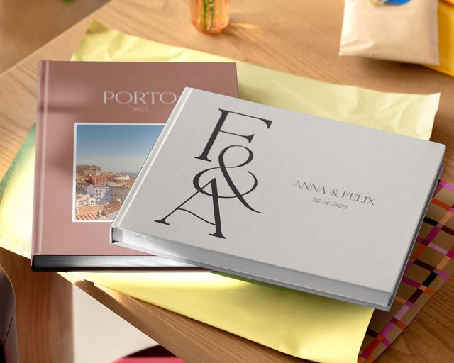 Two personalised photo books displayed on a table in different sizes and designs.