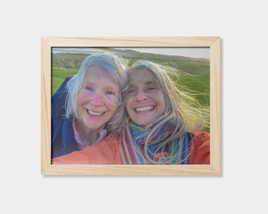 A framed poster featuring an image of two women smiling