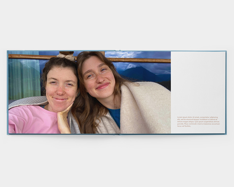 An open landscape layflat photo book with a photo of two women smiling